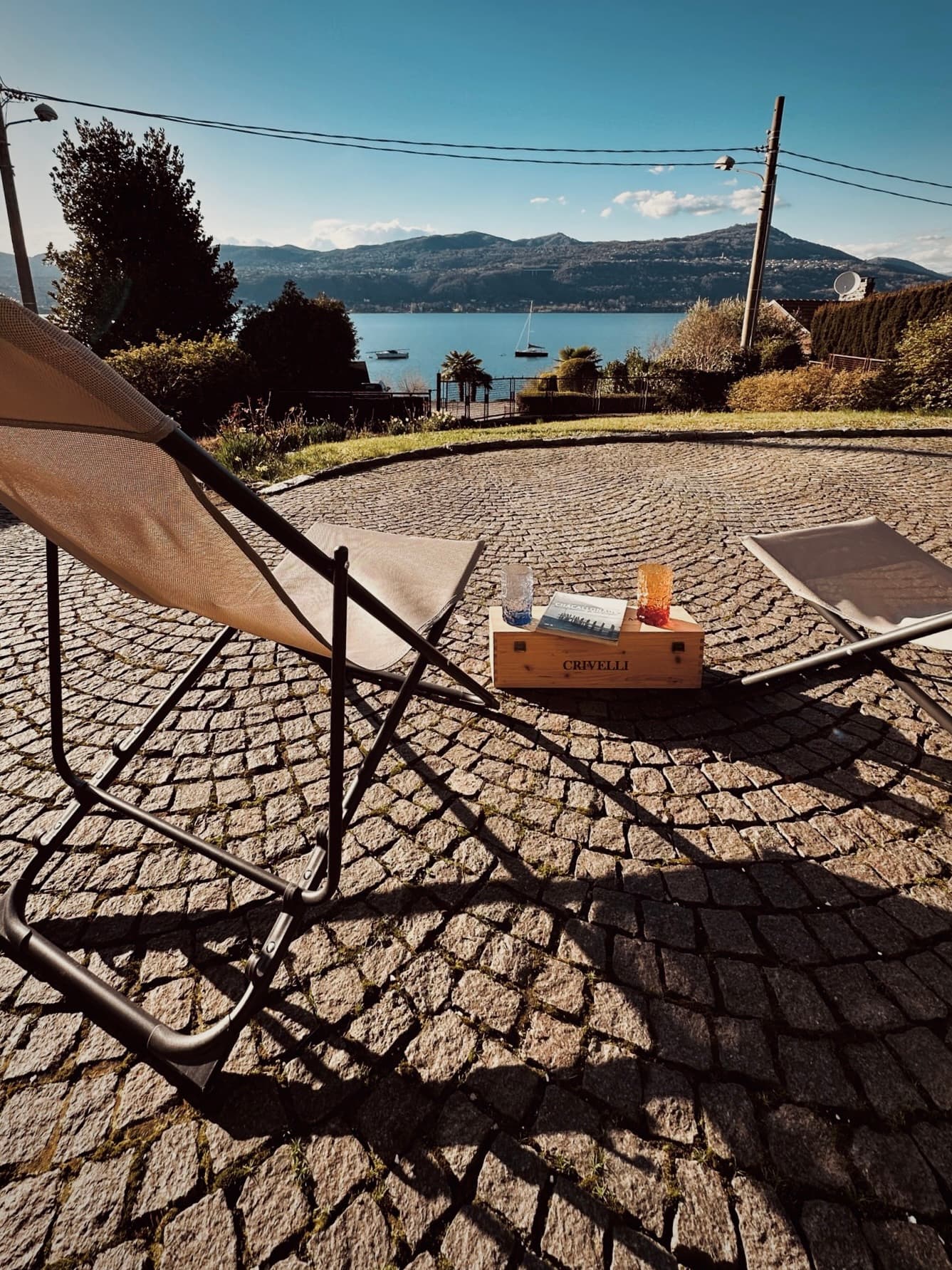 Two lounge chairs on the stone terrace overlooking the lake