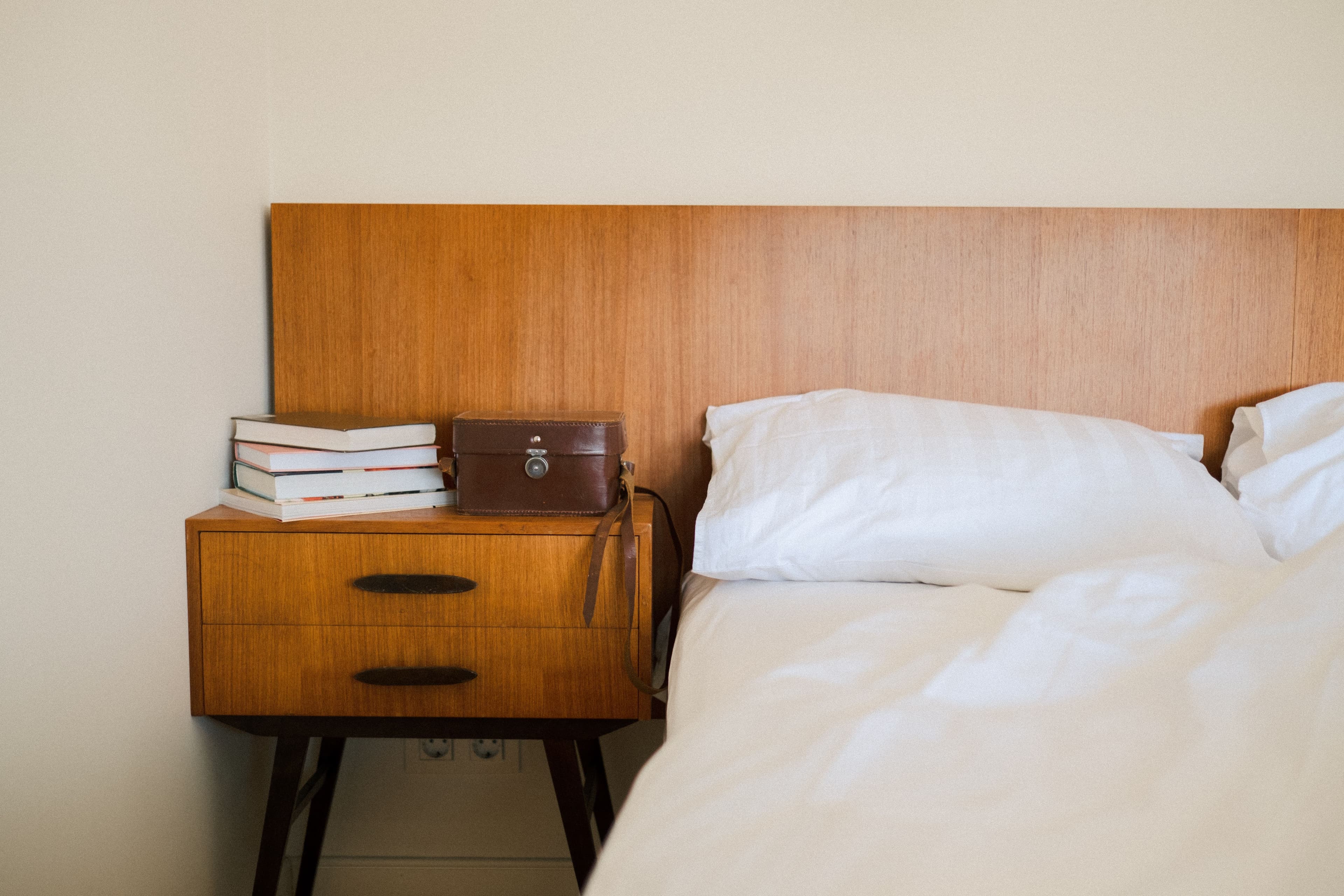 Table de chevet en bois près d'un lit soigneusement préparé